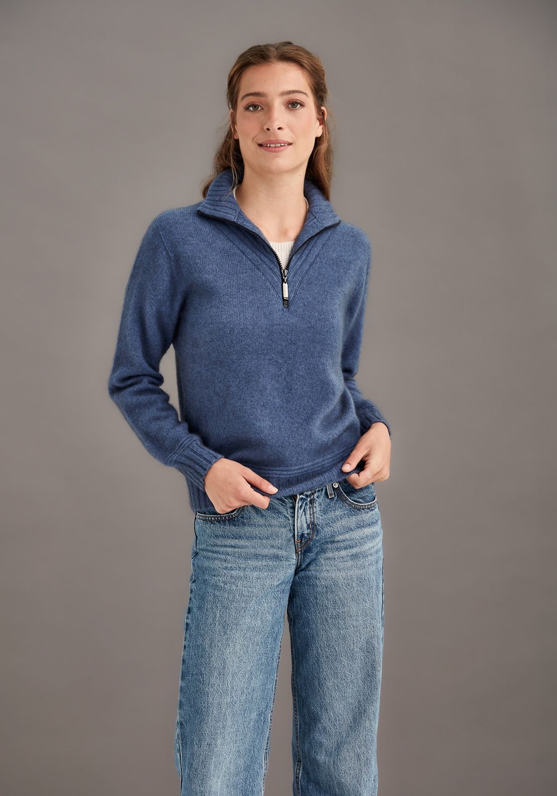 Woman in a blue half-zip wool sweater
